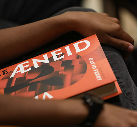 Student holding copy of the Aeneid on their lap