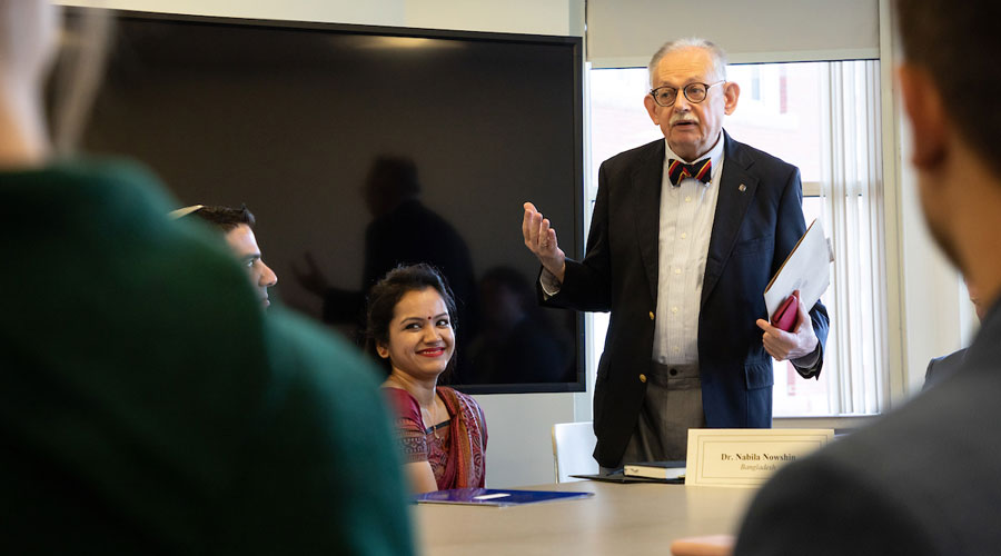 A Suffolk professor talks to his class before a diplomat's presentation.