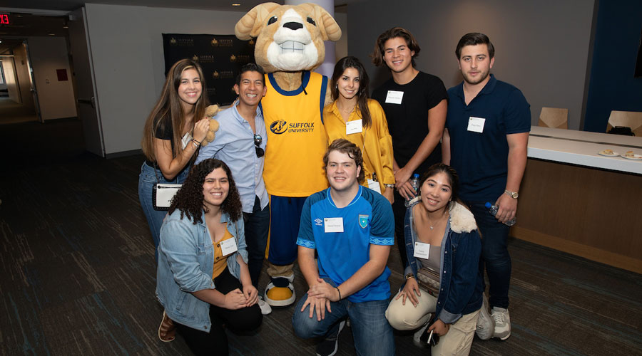 A group of international Suffolk students pose with the University mascot, Rammy.