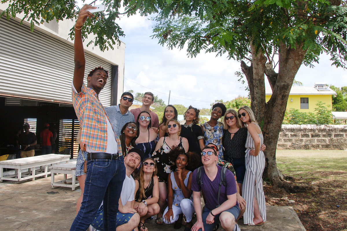 Suffolk Journey students pose for a photo with some of the native people of Barbados during a visit.