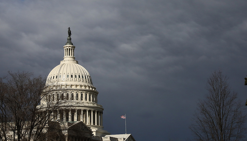 Capitol dome shines against dark clouds