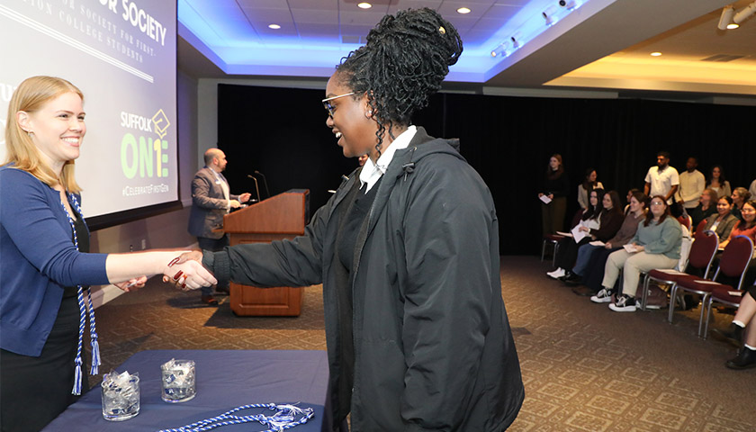 Professor Kelsey Stocker shakes hands with student Areta Odiah