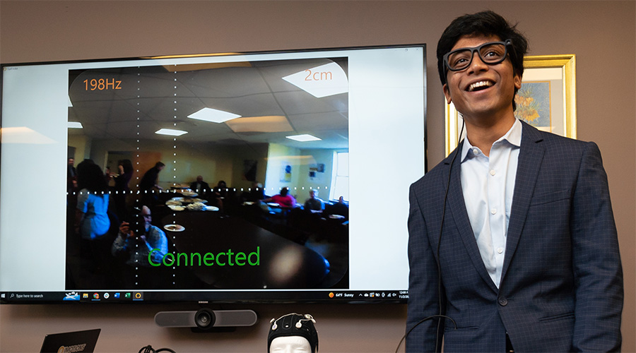A student stands in front of a display in the Sawyer Business School's X-Lab