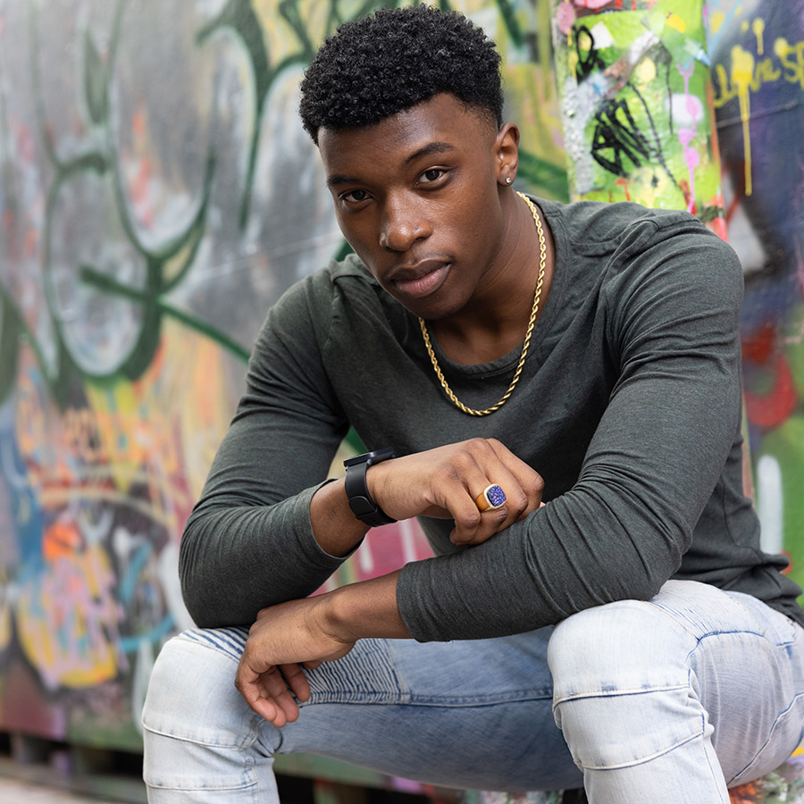 Suffolk student Ahmad poses for a portrait in Graffiti Alley in Cambridge.