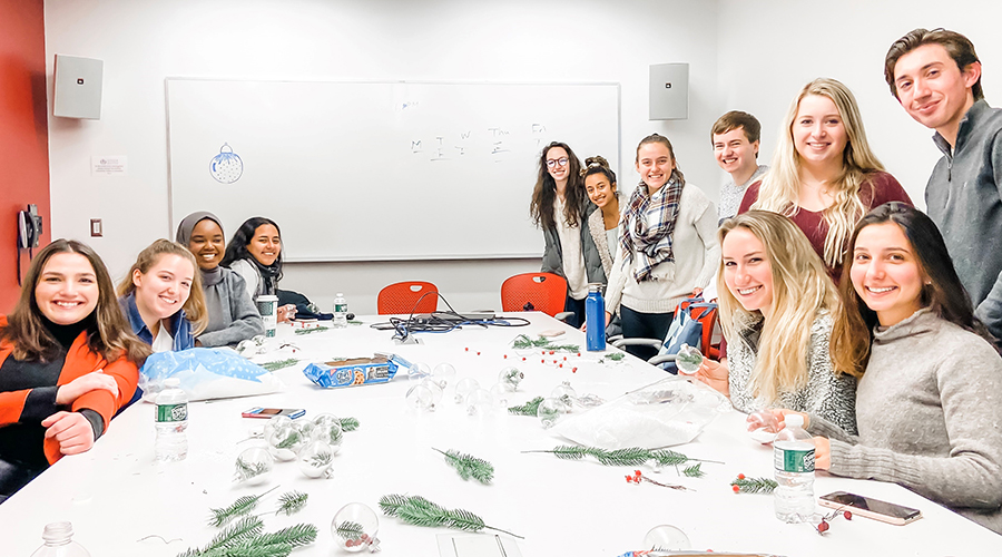 Group of students gathered at a large table making ornaments