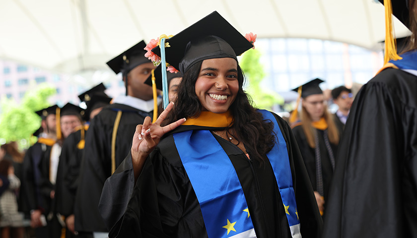 A CAS student smiles in line at the Leader Bank Pavilion during the Commencement 2024 ceremony