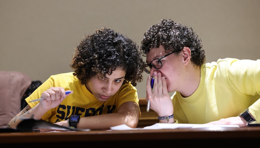 David Rivera leans in to whisper to his debate partner, Marcela De Souza, during a round 
