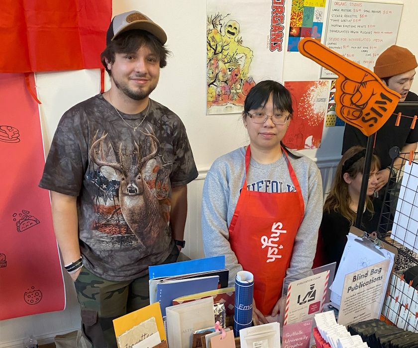 Nick Zujus and Elaine Jue stand behind the Suffolk table at the Boston Art Book Fair