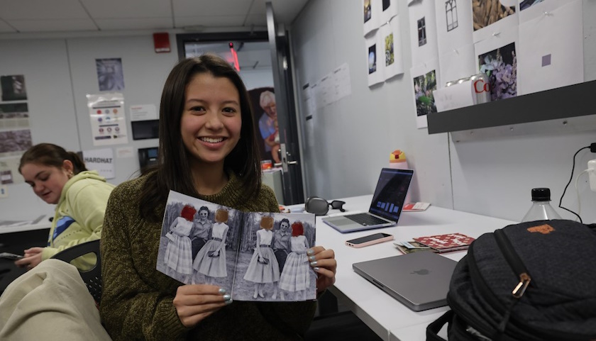 Karis Hakala holds her work, a booklet, in the design lab