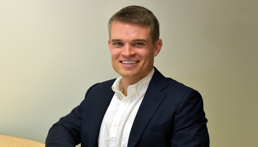 Ryan Mace smiles while seated at a table