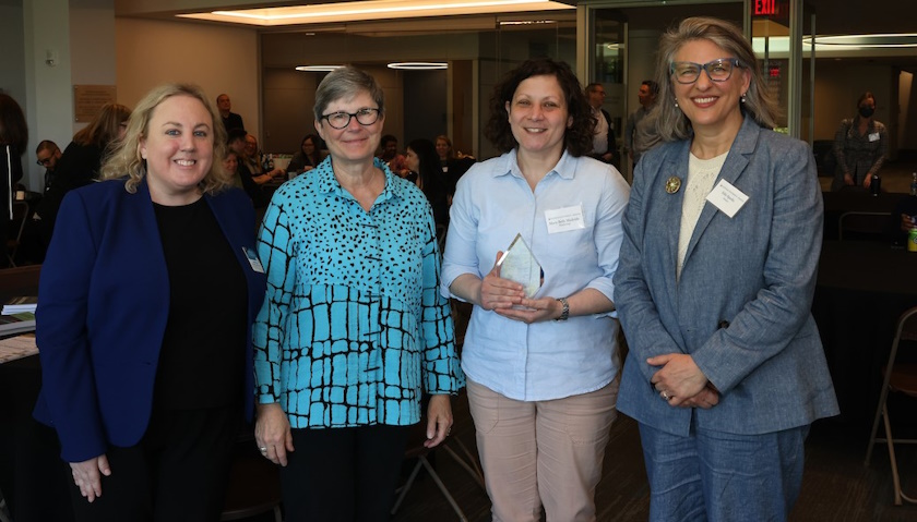 Mary Beth Medvide holds a glass award while standing with CTSE Director Rachel Plews, Provost Julie Sandell and CAS Dean Edie Sparks