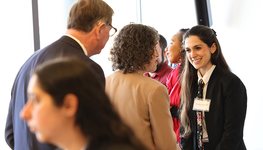 Attendees at the Well-Being Summit wait to talk to a bar representative