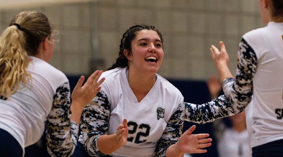 Jayla Martinez cheering with two of her volleyball teammates