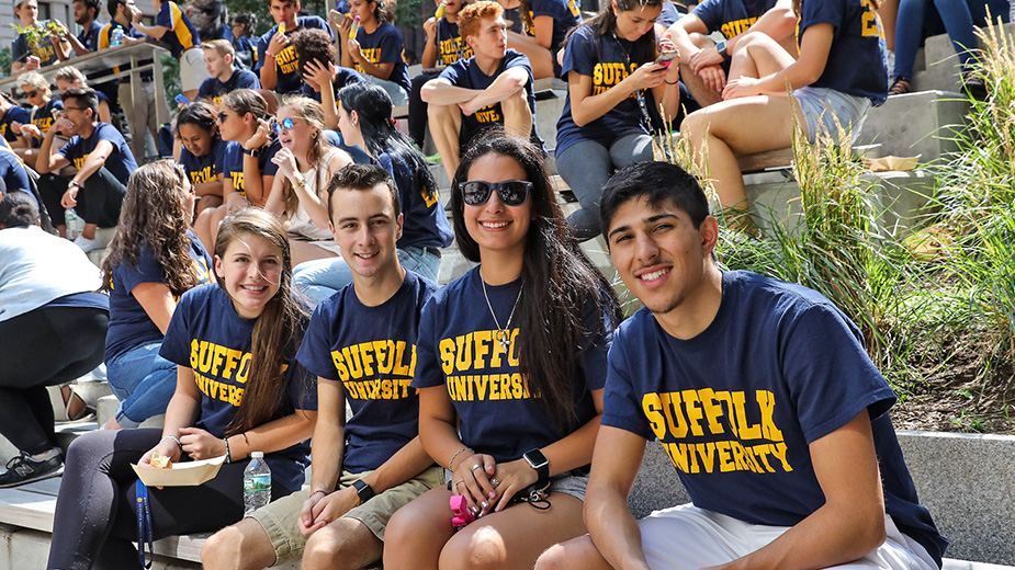 Four new Suffolk students pose together at a Welcome cookout in Roemer Plaza.