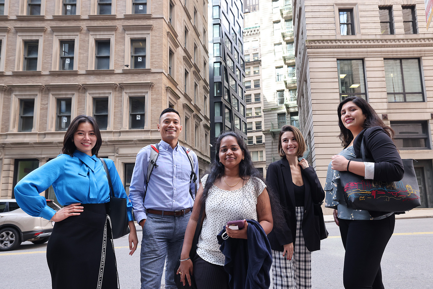 Sawyer Business School graduate students stand in front of Boston high rises.